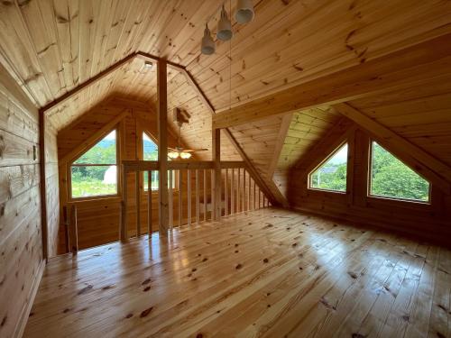 an attic room with wooden floors and windows at Biwako Hills Resort - Vacation STAY 94635v in Takashima