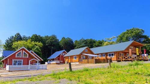 a group of wooden cabins in a field at Biwako Hills Resort - Vacation STAY 94635v in Takashima