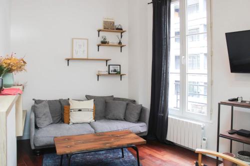 un salon avec un canapé et une table dans l'établissement Atypical cocoon at the foot of Montmartre, à Paris