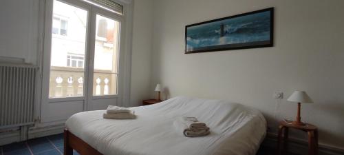 a bedroom with a white bed with towels on it at Eole in Wimereux