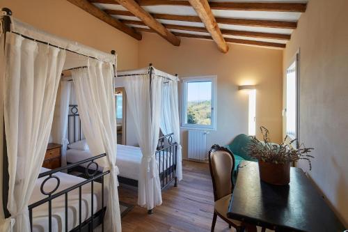 1 dormitorio con cama, mesa y comedor en Villa Grene - Homelike Villas, en Grosseto