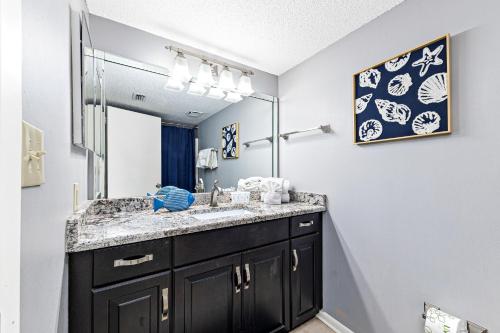 a bathroom with a sink and a mirror at Phoenix East 904 in Orange Beach