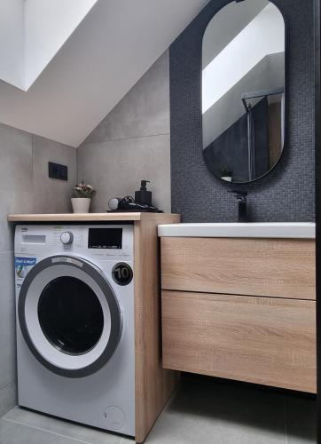 a bathroom with a washing machine and a mirror at Near the airport- Apartments in Kraków