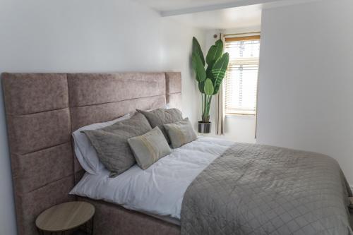 ein Schlafzimmer mit einem großen Bett und einer Pflanze in der Unterkunft Oasis Retreat Hot Tub Cupar in Cupar