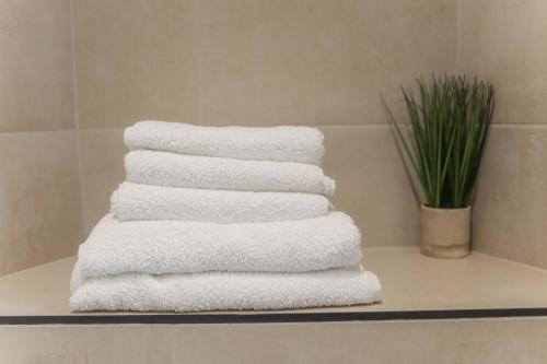 a stack of white towels on a shelf in a bathroom at Oasis Retreat Hot Tub Cupar in Cupar