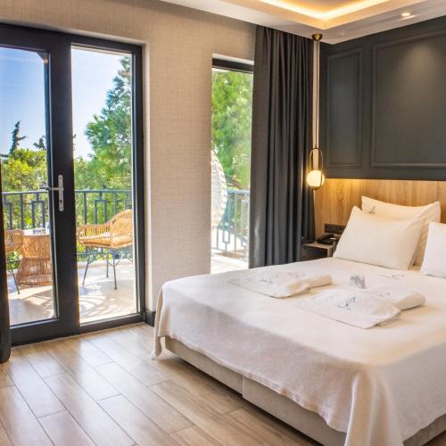 a bedroom with a bed and a balcony at CUNDA PİER OTEL in Ayvalık