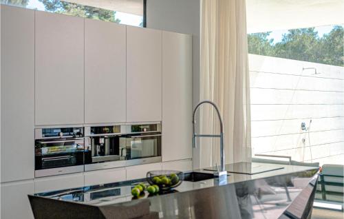 a kitchen with white cabinets and a counter with a sink at Villa Soiree in Starigrad