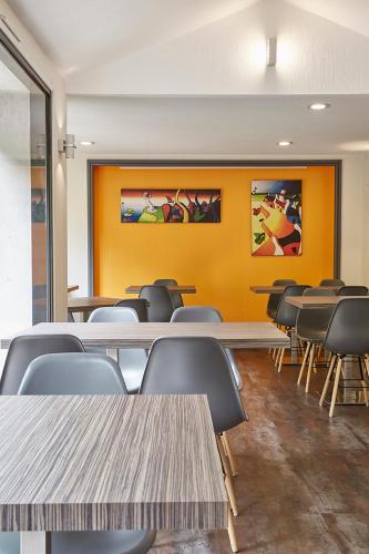 a classroom with tables and chairs and a yellow wall at The Originals City, Hôtel Les Océanes, Lorient in Lorient