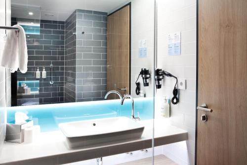 y baño con lavabo y espejo. en Holiday Inn Express Fürth, an IHG Hotel en Fürth