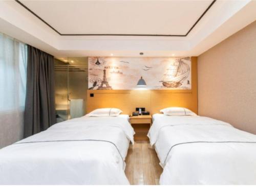 a row of white beds in a room at Yi Nuo Hotel Guangzhou in Guangzhou