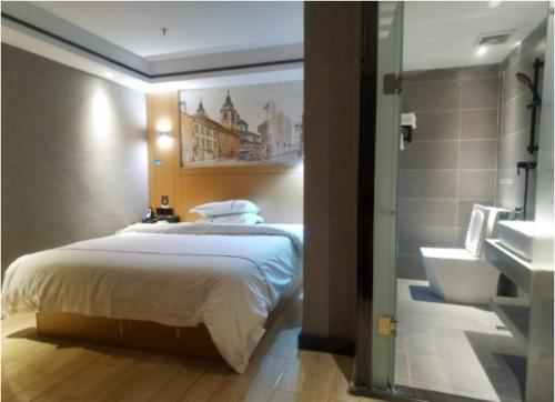 a bedroom with a bed and a bathroom with a sink at Yi Nuo Hotel Guangzhou in Guangzhou