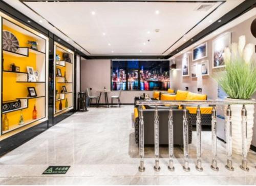 a living room with yellow chairs and a bar at Yi Nuo Hotel Guangzhou in Guangzhou