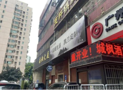 a building with signs on it in a city at Yi Nuo Hotel Guangzhou in Guangzhou