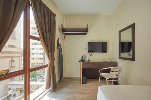 um quarto com uma cama, uma secretária e uma janela em Bpod near Dataran Merdeka/Masjid Jamek LRT em Kuala Lumpur