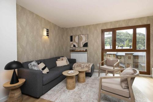 una sala de estar con un sofá y una silla en Casa Pareja by BeValle, en Panticosa
