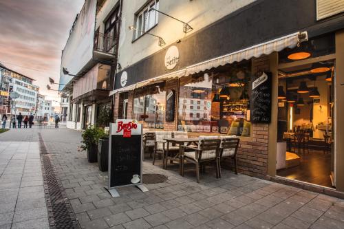 ein Restaurant auf einer Straße mit einem Schild davor in der Unterkunft Petit Dependance in Bratislava