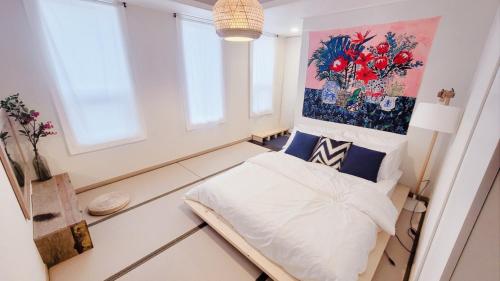 a bedroom with a bed and a painting on the wall at White Casa in Seogwipo