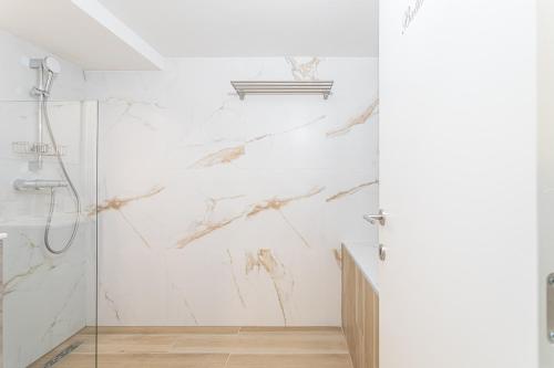een witte badkamer met een douche en een glazen deur bij Studio1 Van Lerius in Antwerpen