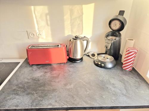 a kitchen counter top with a toaster and a clock at Maison à Aurillac - 3 chambres - Arrivée autonome in Aurillac