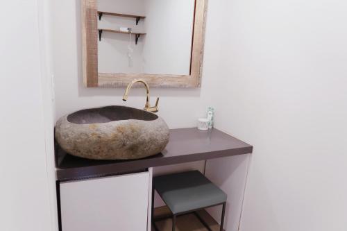 a bathroom with a stone sink and a mirror at White Casa in Seogwipo