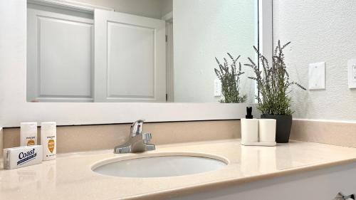 a bathroom counter with a sink and a mirror at HSO - Family Apartments Close to Disney World & Universal in Orlando