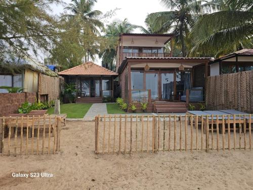 a house with a fence and tables in front of it at Agonda Beach Villa in Agonda
