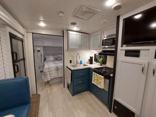 an rv kitchen with a sink and a bed at The Torres' Camper Experience! in Tampa