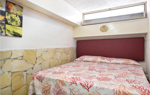 Dormitorio pequeño con cama con pared de roca en Gorgeous Apartment In Brucoli With Kitchen, en Brucoli