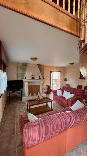 ein Wohnzimmer mit roten Sofas und einem Klavier in der Unterkunft Villa Artegoikoa in Ibarrangelu