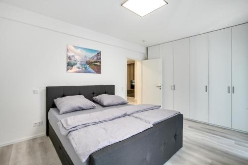 um quarto com uma cama grande e armários brancos em Mont Apartments em Düsseldorf