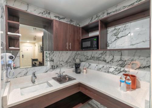 a kitchen with a sink and a mirror at Sunshine Inn in Kissimmee