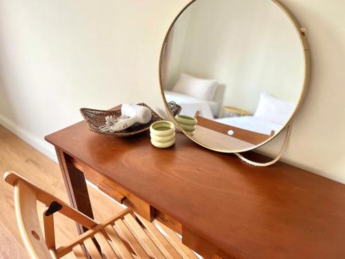 a mirror on top of a wooden table with a bed at IKO homes in Kota Kinabalu