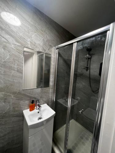 a bathroom with a sink and a shower at Flat in London in London