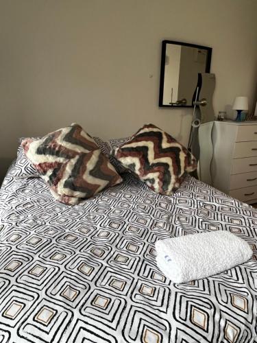 a bed with two pillows on it in a bedroom at Flat in London in London
