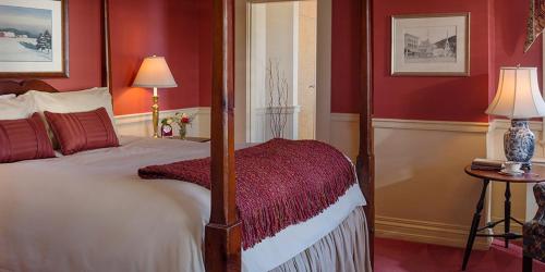 a bedroom with a bed with red walls at Green Mountain Inn in Stowe