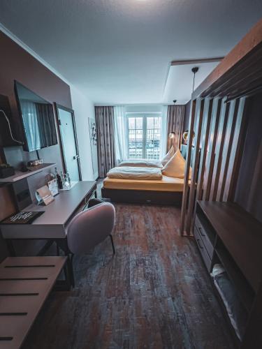 a small room with a bed and a desk at Restaurant Hotel Goldener Adler in Emden
