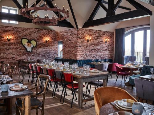 a restaurant with tables and chairs and a brick wall at The Harper in Langham