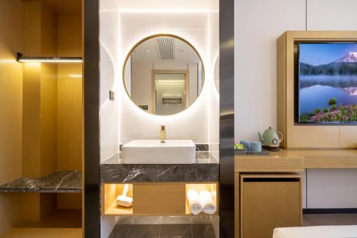 a bathroom with a sink and a mirror at Oriental Sundar Hotel near China-Japan Friendship Hospital-Bird's Nest and Water Cube-Yonghe Palace-Nanluoguxu Alley in Beijing