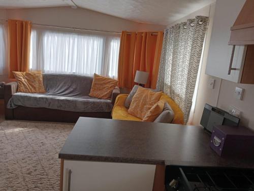 a living room with a couch and a living room with orange curtains at 19 Chaffron in Hull