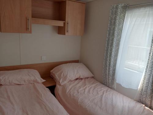 2 camas en una habitación pequeña con ventana en 19 Chaffron, en Hull