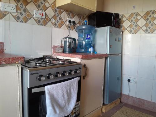 a kitchen with a stove and a refrigerator at Homestyle Haven with Secure Parking & Free WiFi in Embu