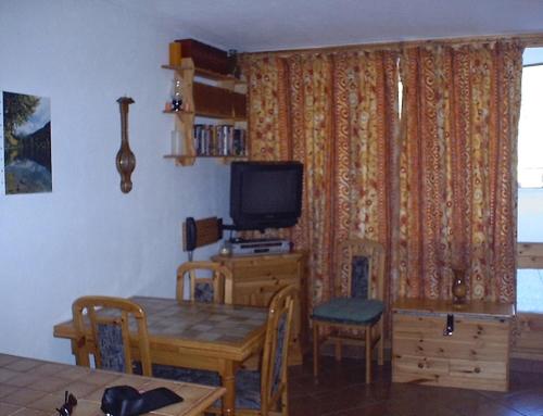 a dining room with a table and a television at Aurore 554 in Le Sauze