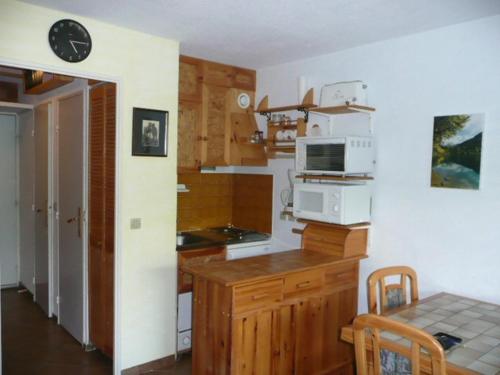 a kitchen with a microwave and a table with a dining room at Aurore 554 in Le Sauze