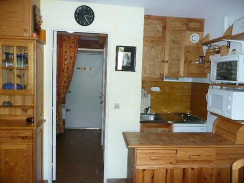 a kitchen with a counter and a clock on the wall at Aurore 554 in Le Sauze