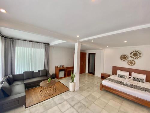 a living room with a bed and a couch at Grey House Monkey Forest in Ubud