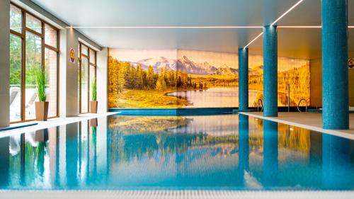 a swimming pool with a mountain mural on the wall at SZKLARSKA VIEW Luxury Apartment Jacuzzi in Szklarska Poręba