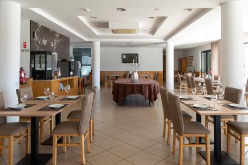 een eetkamer met houten tafels en stoelen bij Hotel Durao in Viseu