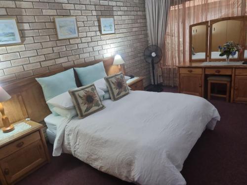 a bedroom with a large white bed and a mirror at Villa Majestic for Exclusive Accommodation in Port Alfred