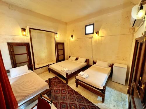 um quarto com três camas e um tapete em Taşkıran Boutique Hotel em Şanlıurfa