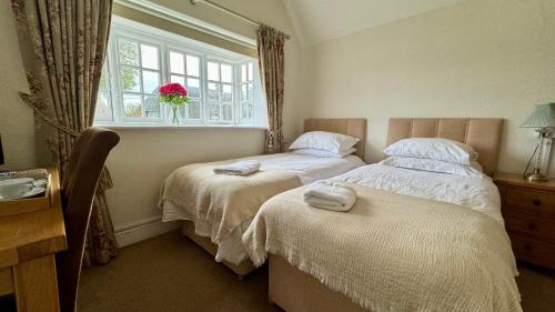 a bedroom with two beds and a window at The Cricketers Inn in Winchester